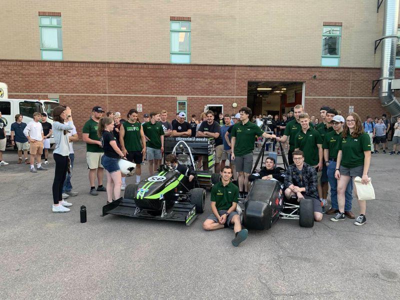 A photo of the formula sae electric team standing around their car